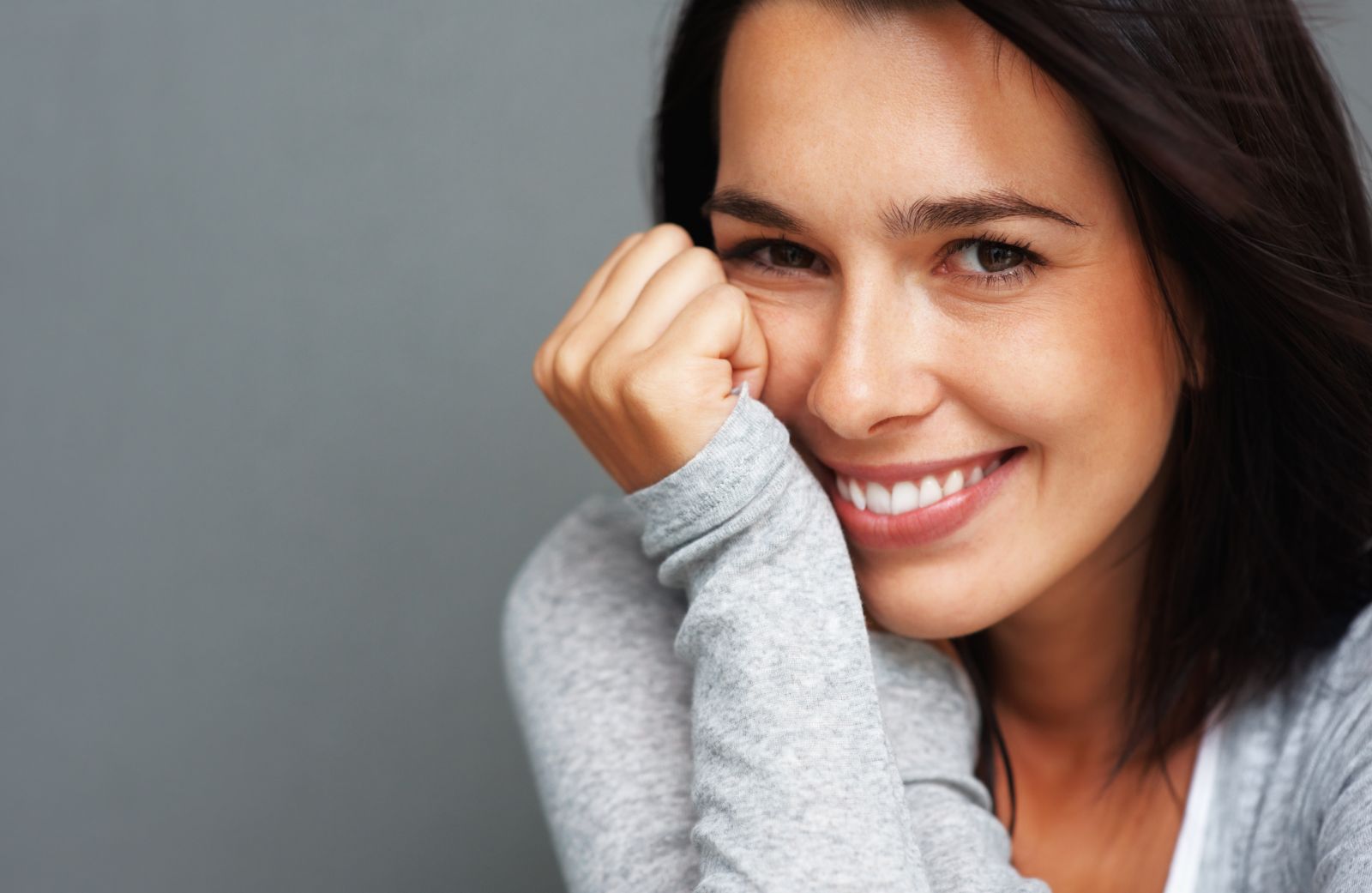 woman smiling leaning on hand, cosmetic dentistry in Woodbridge, VA