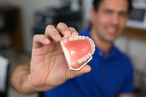 man holding up dentures Woodbridge, VA dental restorations